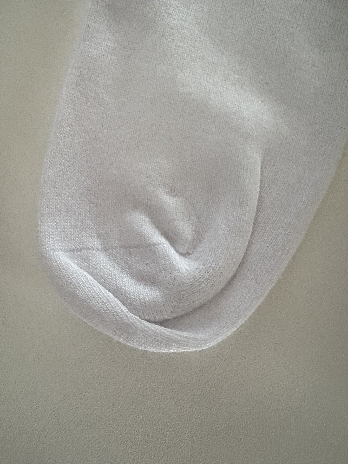 Close-up of a white sock on a beige background