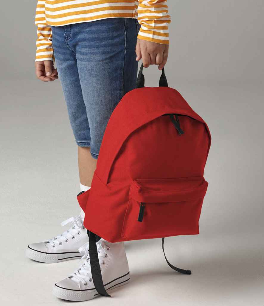 Person holding a red backpack with a neutral background