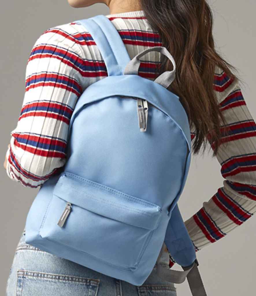 Person wearing a light blue backpack with a striped shirt and jeans.