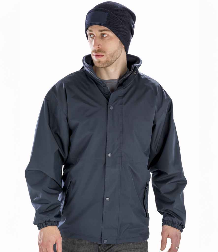 Man wearing a dark gray raincoat and black beanie on a white background