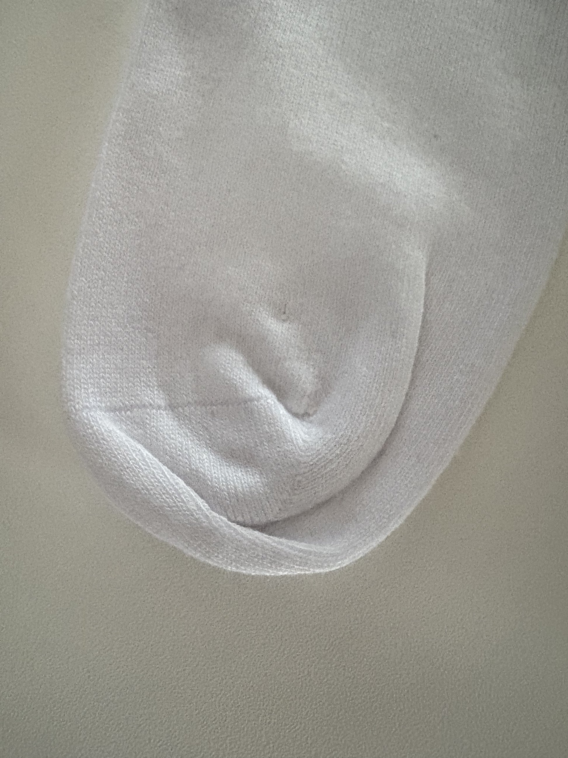 Close-up of a white sock on a beige background